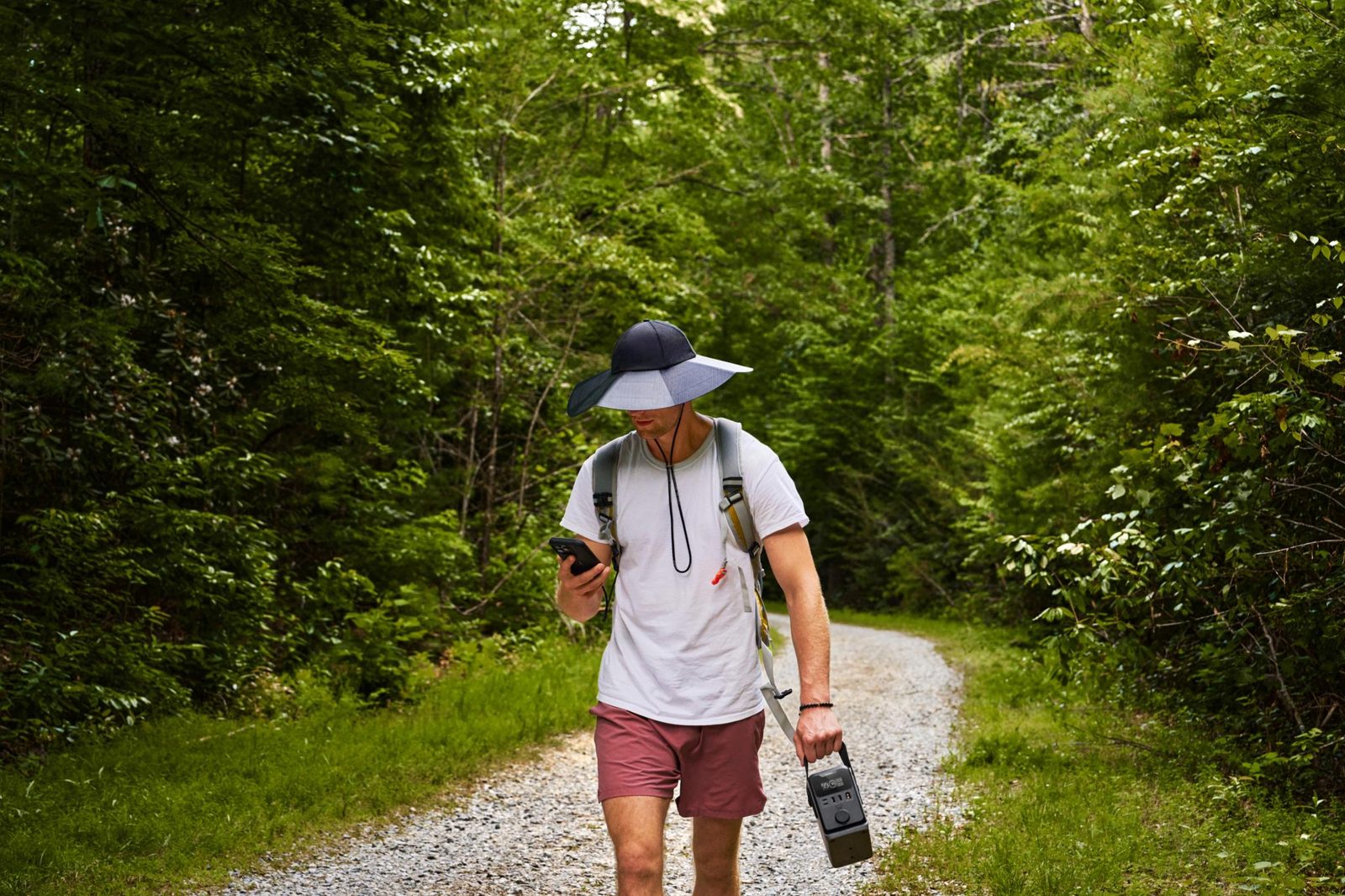 Турист несёт зарядную станцию EcoFlow TRAIL весом менее 3 кг на лесной тропе